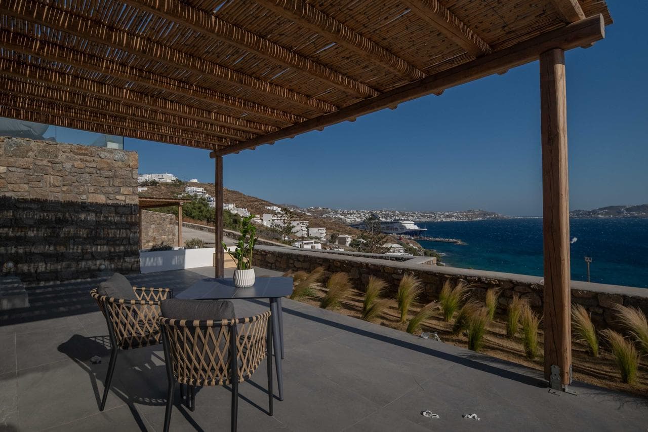 Pergola-shaded terrace overlooking the Mykonos coastline