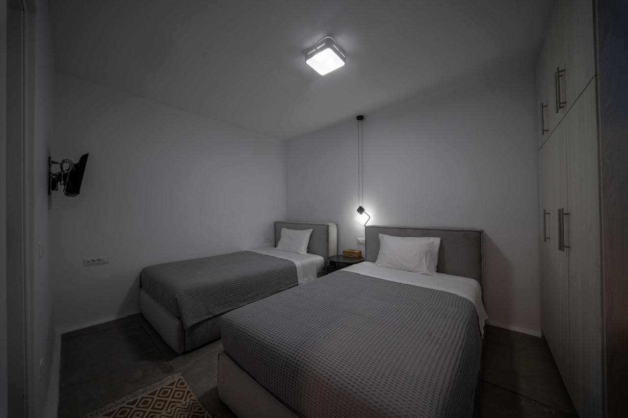 Twin bedroom with grey bedspreads and pendant lights